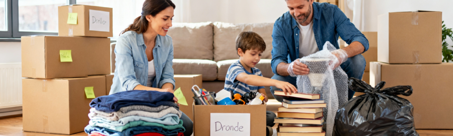 Tri et préparation du déménagement – Méthode des trois piles Famille organisant le tri pré-déménagement avec trois piles distinctes : garder, donner et jeter, tout en préparant des cartons étiquetés