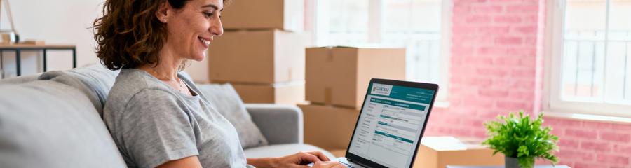 Femme remplissant formulaire devis déménagement en ligne sur ordinateur, appartement Toulouse