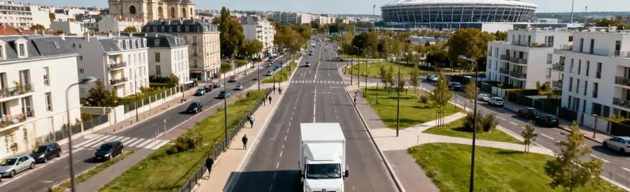 Camion de déménagement circulant à Saint-Denis avec la Basilique royale et le Stade de France en arrière-plan