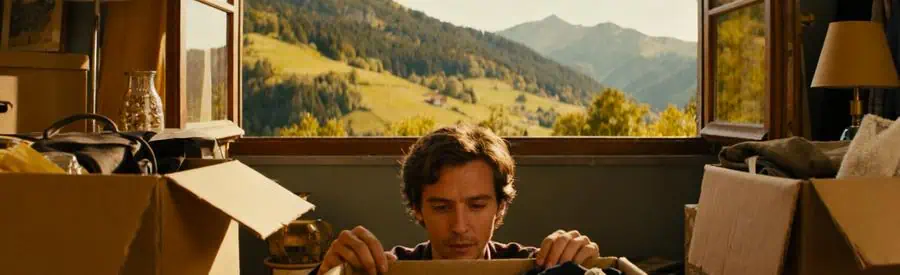 Personne faisant le tri dans des cartons ouverts pour préparer son déménagement dans les Vosges.