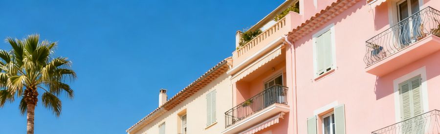 Déménageurs déchargeant des cartons devant un immeuble ensoleillé sur la Côte d'Azur
