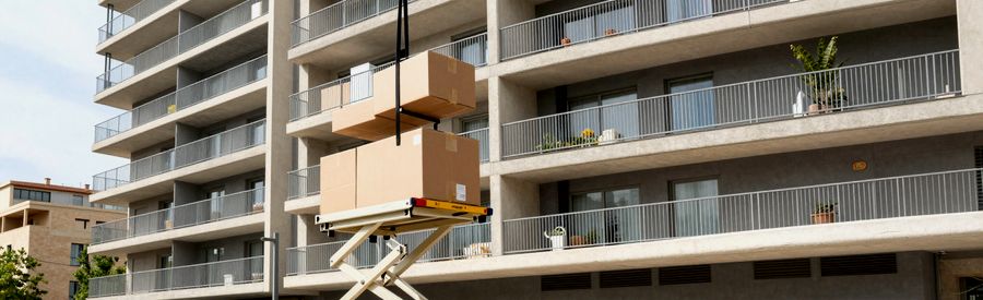 Monte-meuble hissant des cartons vers un balcon à Port Marianne, tramway en arrière-plan